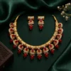 Gold plated kundan necklace set with red stones and pearl drops on dark green royal background traditional bridal jewellery